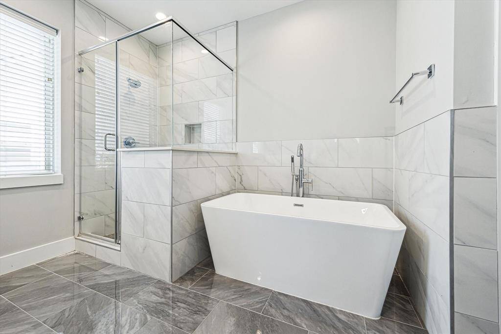 Stylish tile floor and half wall backsplash complement the bathroom. The perfect place to relax!