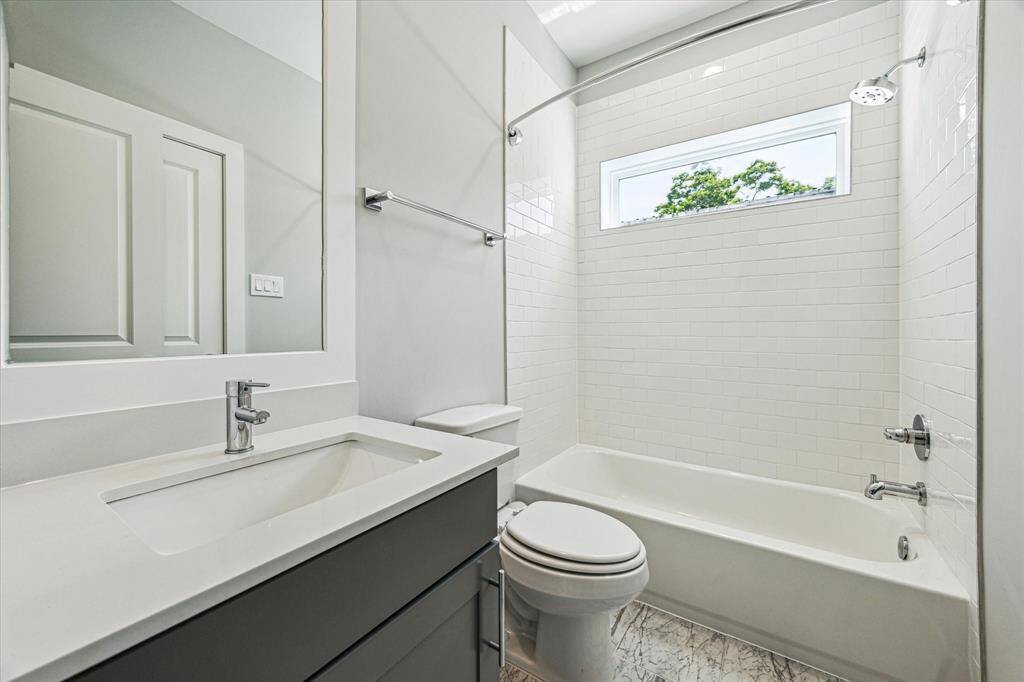 The en-suite first floor bathroom features chic tile flooring, a shower/tub combo, and closet.