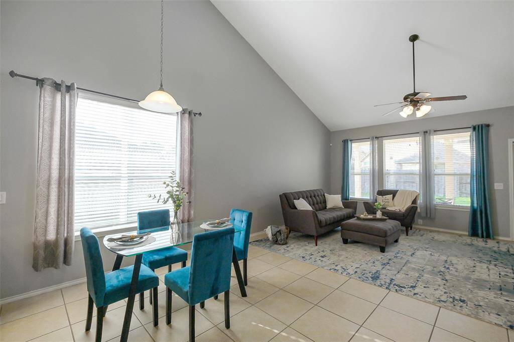 The breakfast area is open to the kitchen and living room. The soaring ceilings and large windows create an inviting space for living and dining.