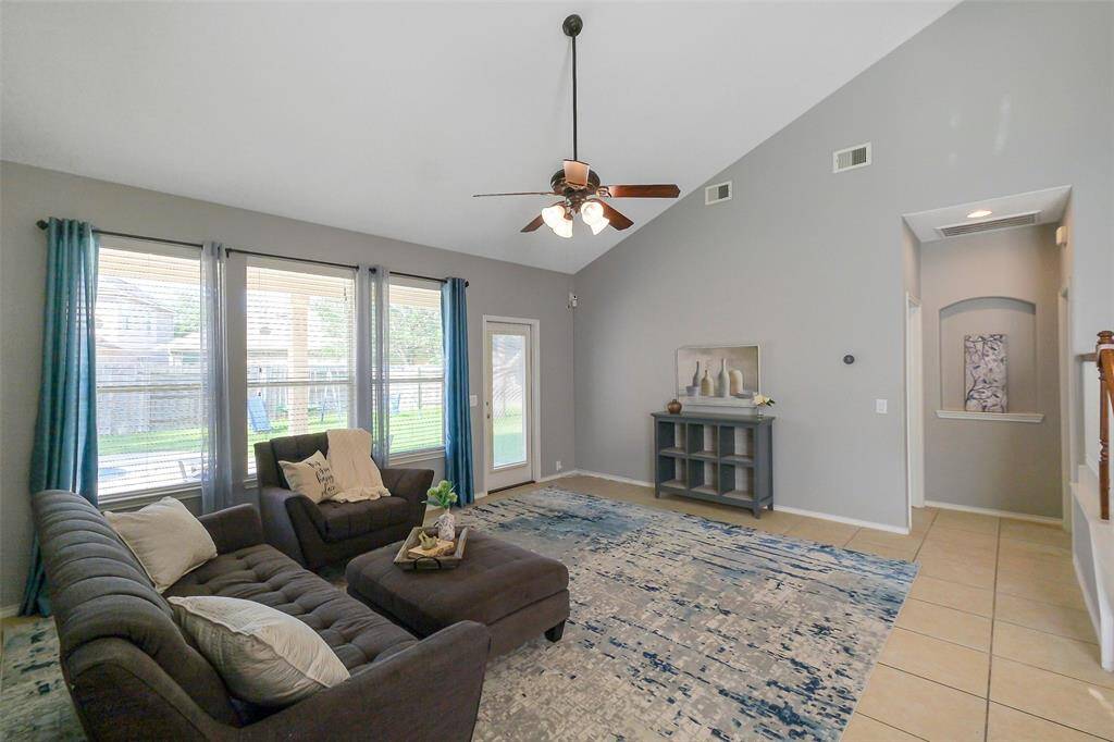 Large windows overlooking the sparking pool and soaring ceilings make this living room the perfect space to relax and enjoy life.
