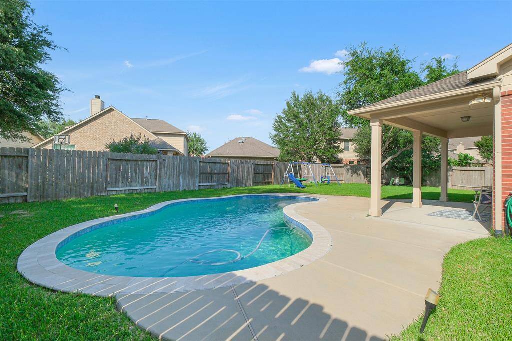The backyard is gorgeous with a sparkling pool and extra green space to enjoy!