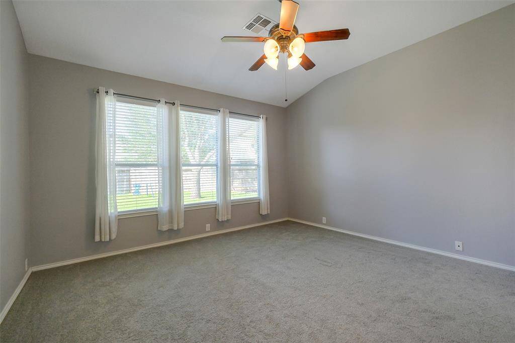 The primary bedroom is downstairs off the living room. It has plenty of space for a king size bed and gorgeous windows overlooking the backyard.
