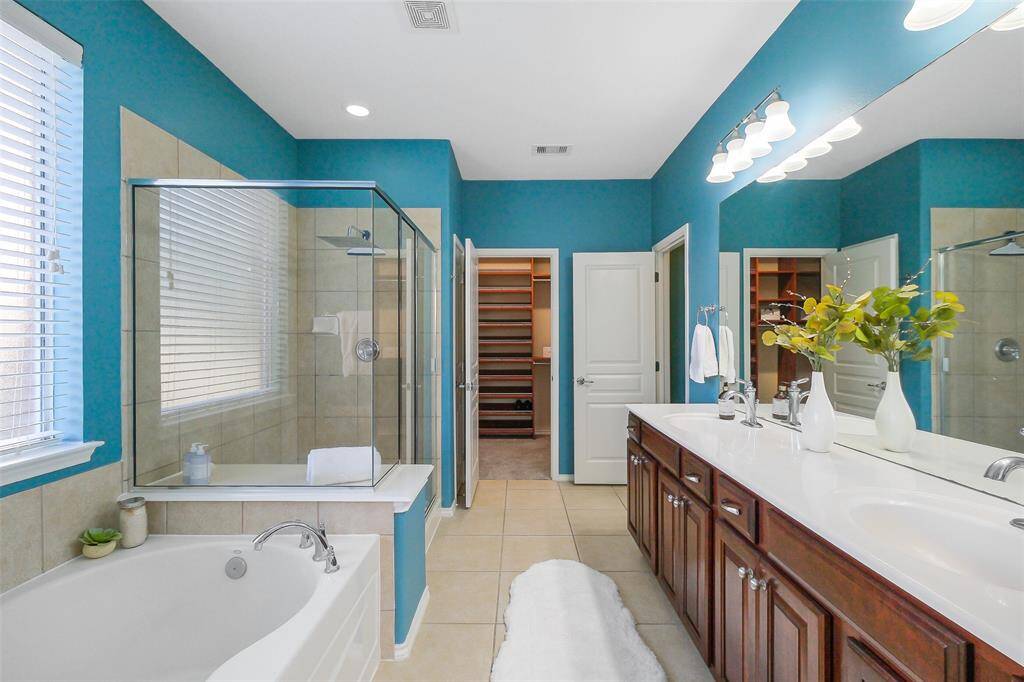 The calming primary bathroom with separate tub and shower, double sinks, and natural light.