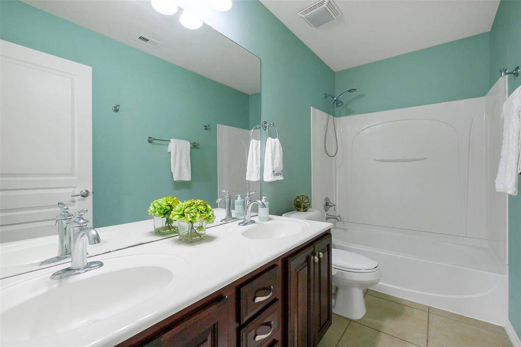The upstairs bathroom features double sinks and a calming color palette.