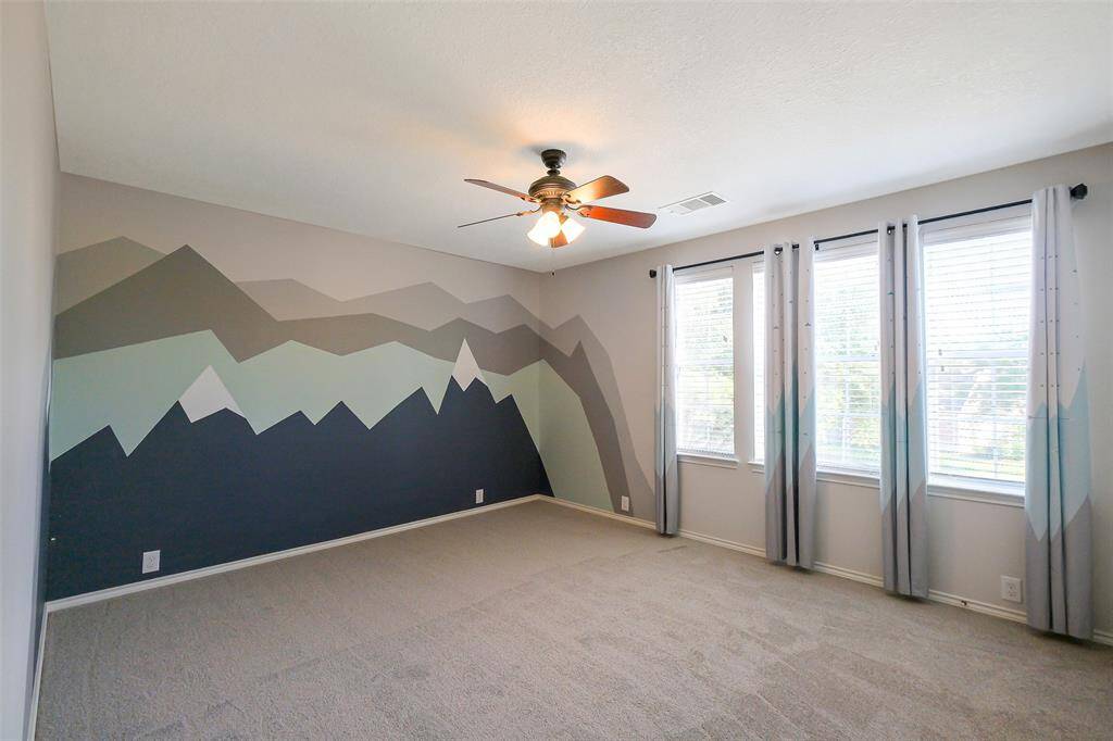 Guest bedroom 1 featuring a custom mural and natural light!
