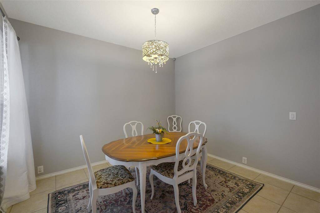 The spacious formal dining room boasts a beautiful light fixture and a large window.