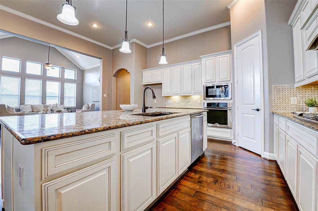 The open layout connects to a bright living area with large windows, offering plenty of natural light and a warm, inviting atmosphere.