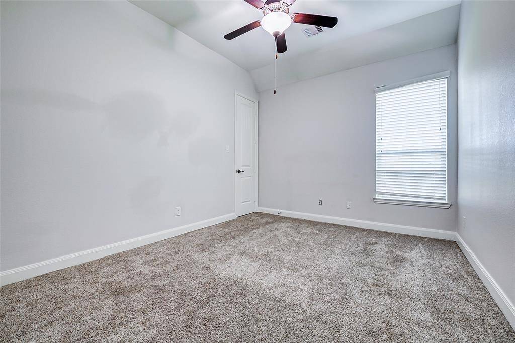 The secondary bedroom is located down the hall from the utility room.