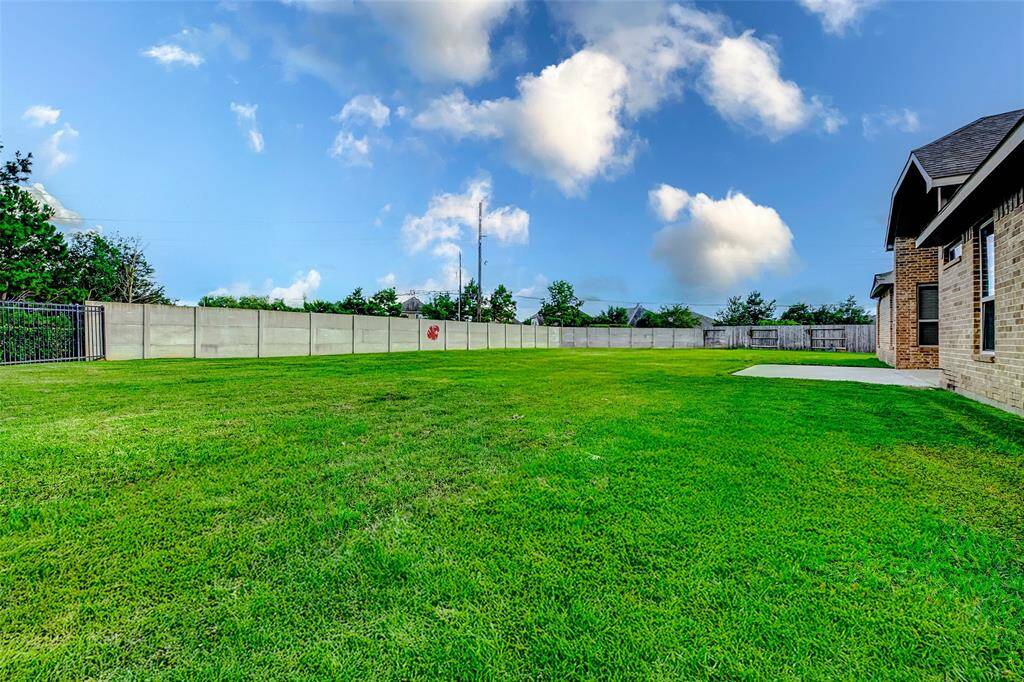 HUGE backyard with lush green lawn, bordered by a privacy fence. Ideal for outdoor activities and entertaining. This yard can be your own private oasis!