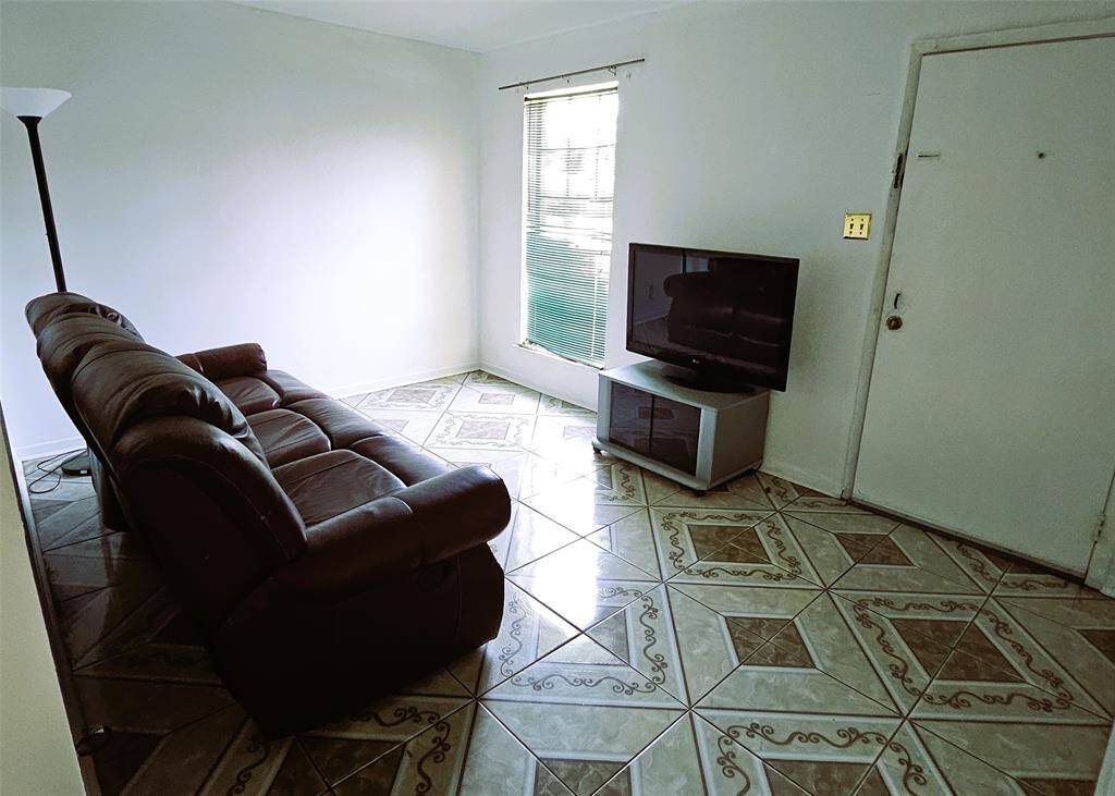 Cozy living room featuring elegant tile flooring, ample natural light, and a welcoming atmosphere perfect for relaxation.