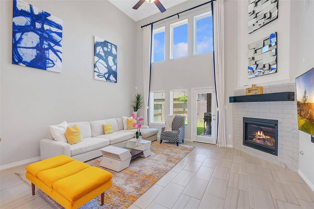 Light, airy and open living room with custom drapery, fireplace and surround sound system in place.