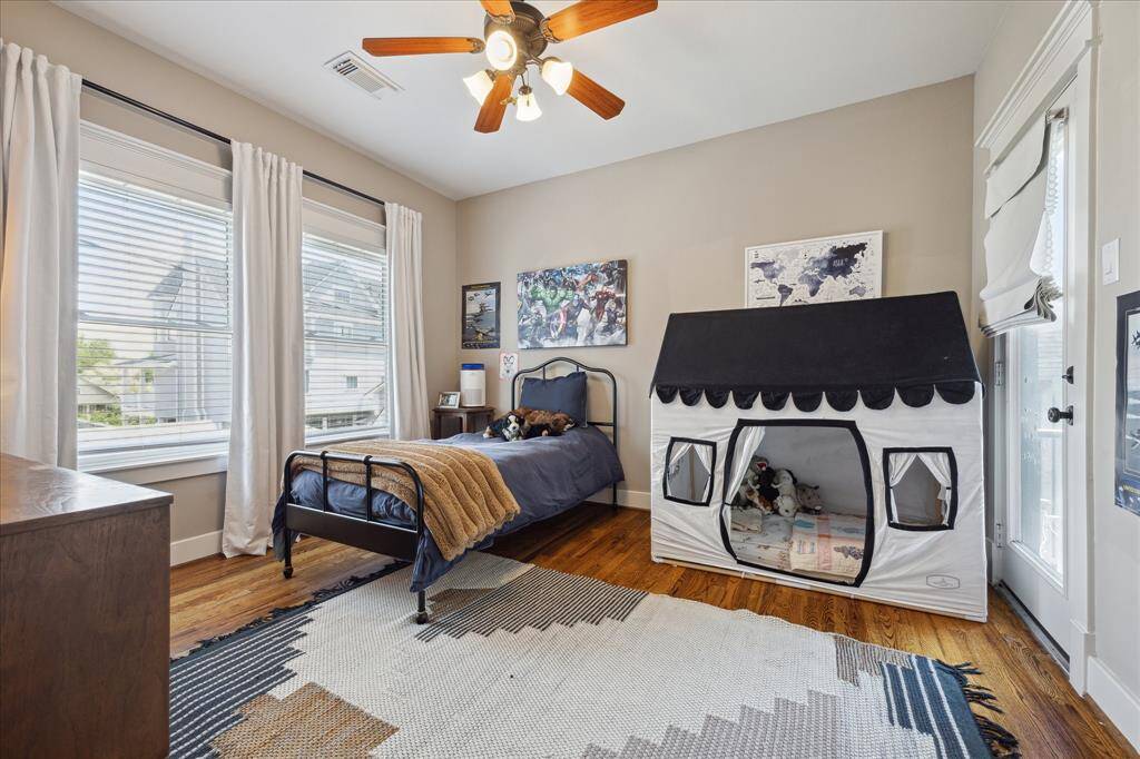 One of the secondary bedrooms located on the second floor; located at the back of the house with access to a balcony that overlooks the backyard.
