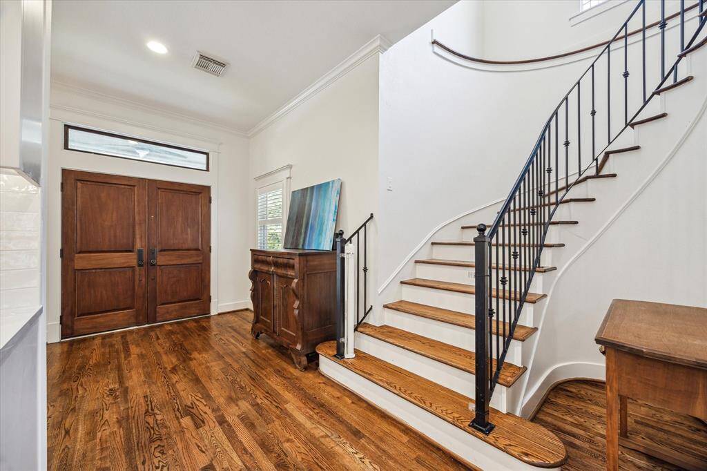 Views of the entryway feature high ceilings and direct view of the staircase.