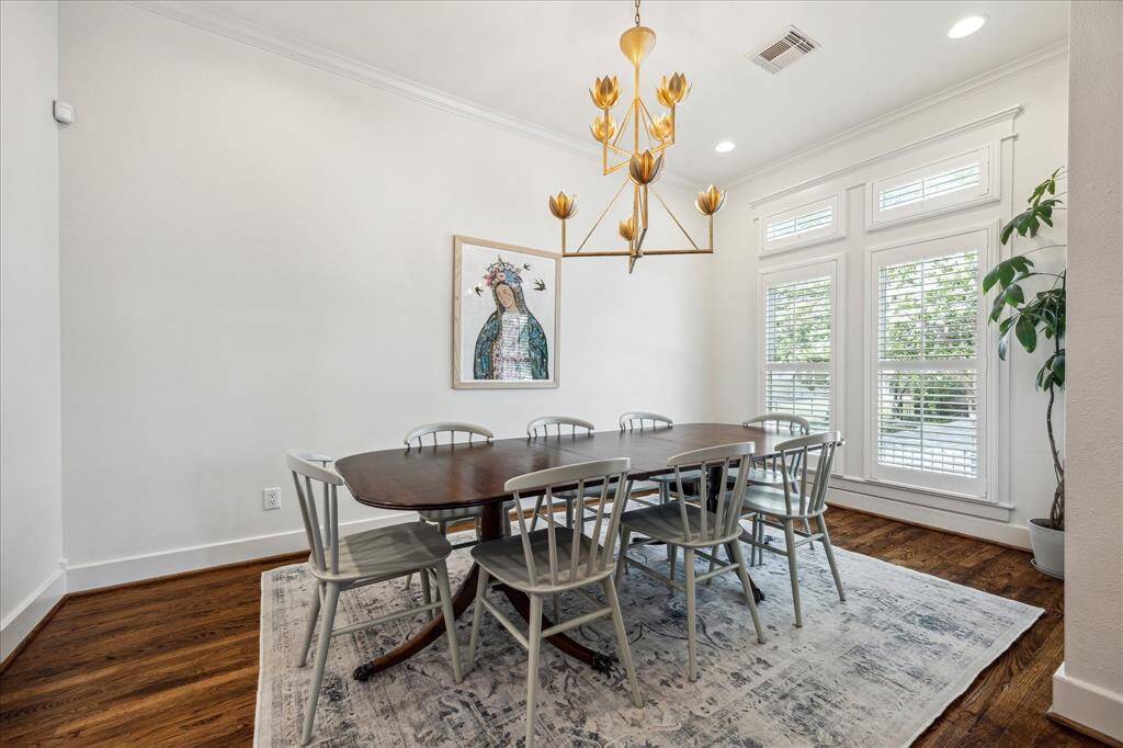 Dining room features large windows, high ceilings and plantation shutters.