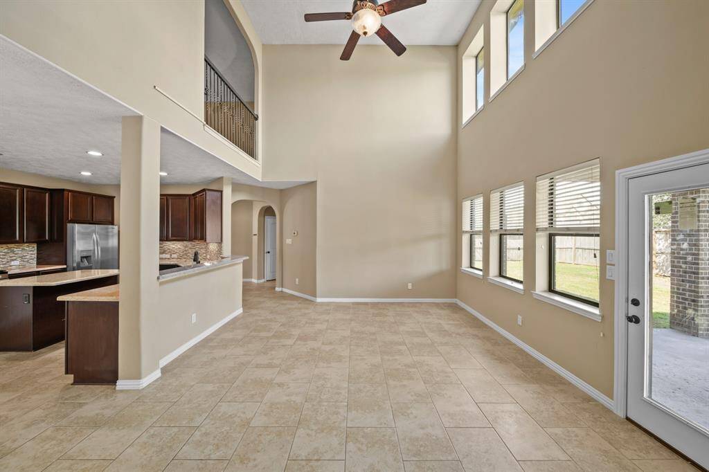 Alternate view of the Luxurious Living Room with ceiling fan with lighting, wall of windows and stunning space for time together