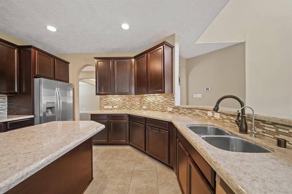 Gourmet Kitchen also offers extended countertops, handsome dark stained cabinetry, and tons of space for multiple cooks in the Kitchen