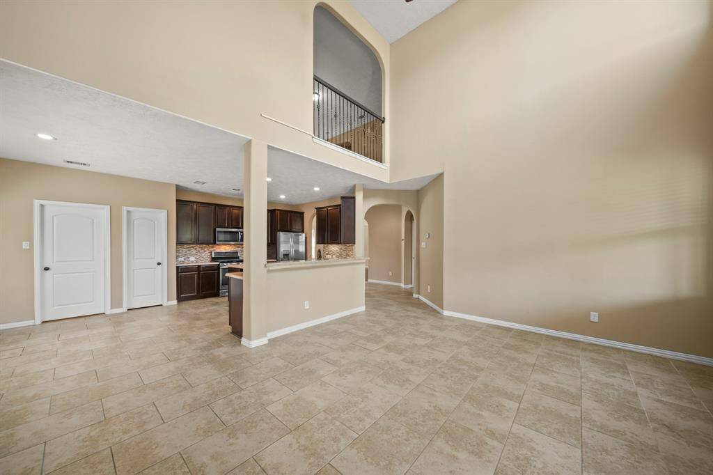 View from the Living Room to the Gourmet Kitchen and upstairs space offered
