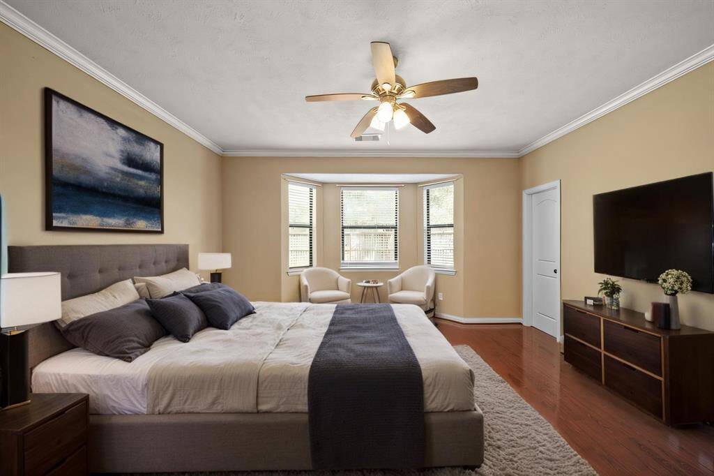 Primary Suite with wood flooring, crown molding and tons of space to retreat to after a long day