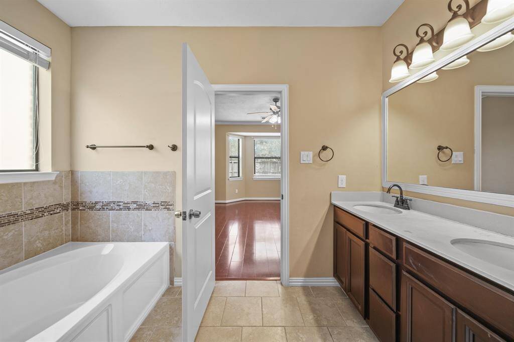 Primary Bathroom features his and her sinks, tile flooring and fabulous fixtures adding to the elegance of the space