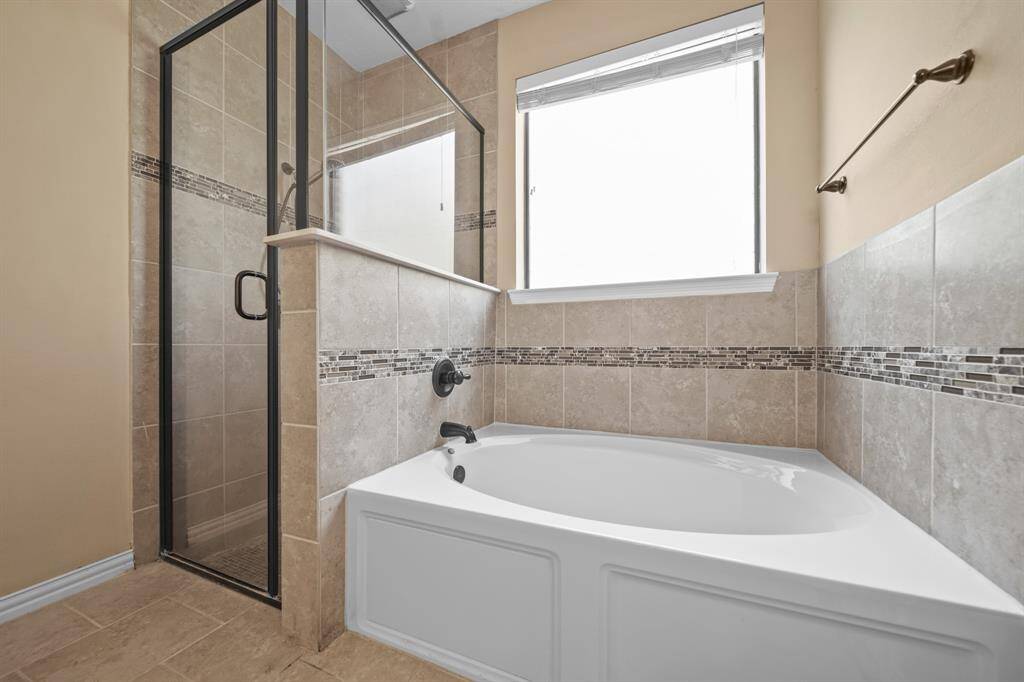 View of the garden tub and glass encased shower to enjoy in the Primary Bathroom Oasis