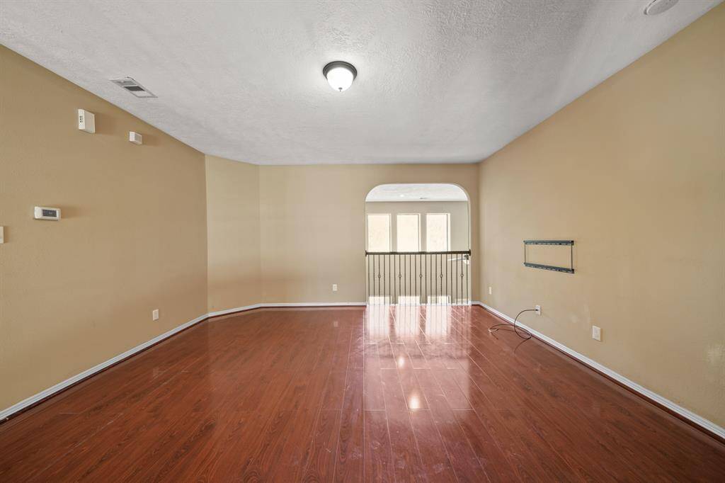 Another Game Room view with wood flooring and space for retreating to on upper level