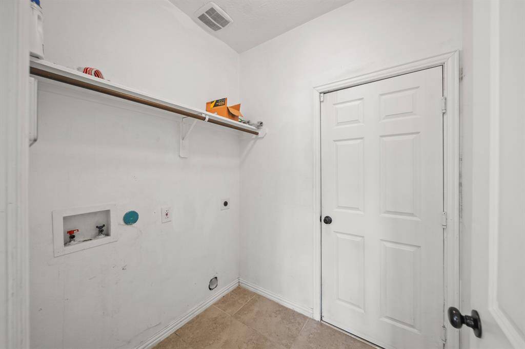 Laundry Room with terrific tile flooring and shelving to assist with laundry and storage