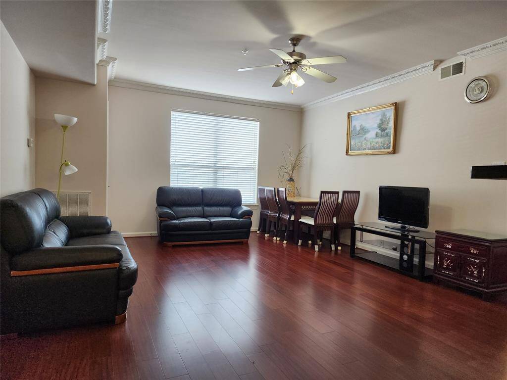 Living/dining combo with ceiling fan and wood floor
