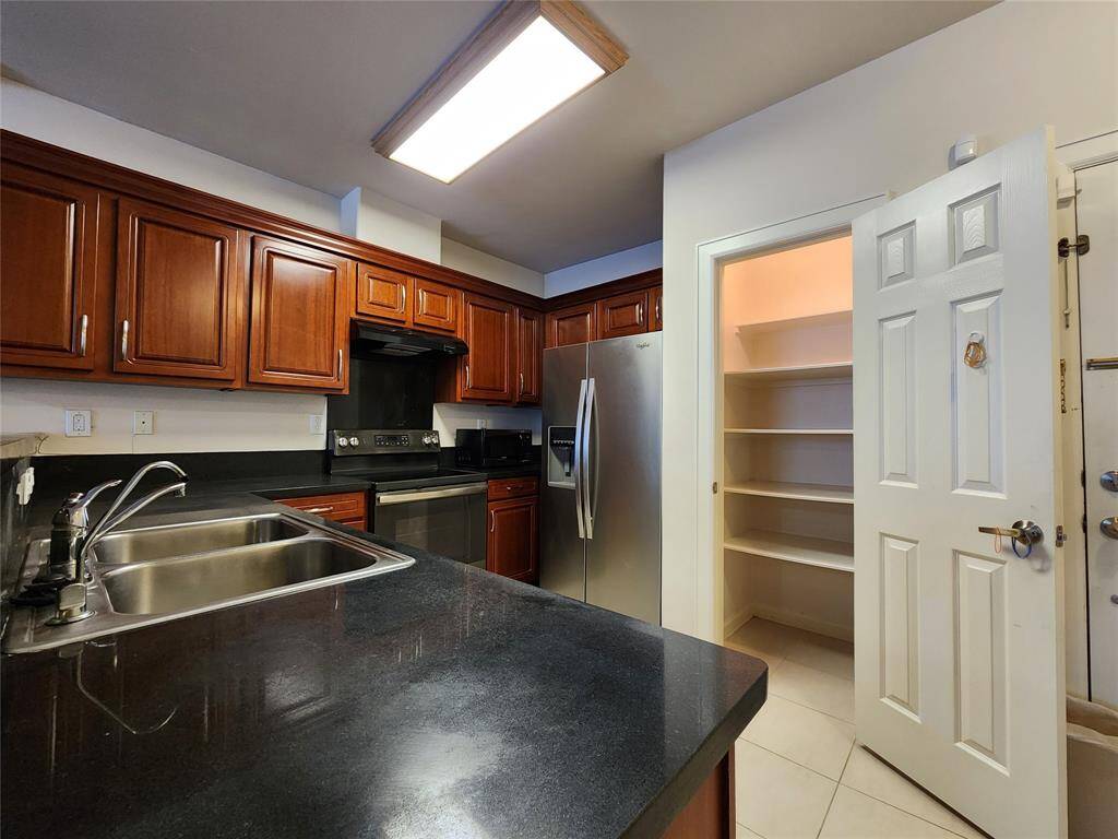 Kitchen with granite counter top, panty with build in shelves, refrigerator included.
