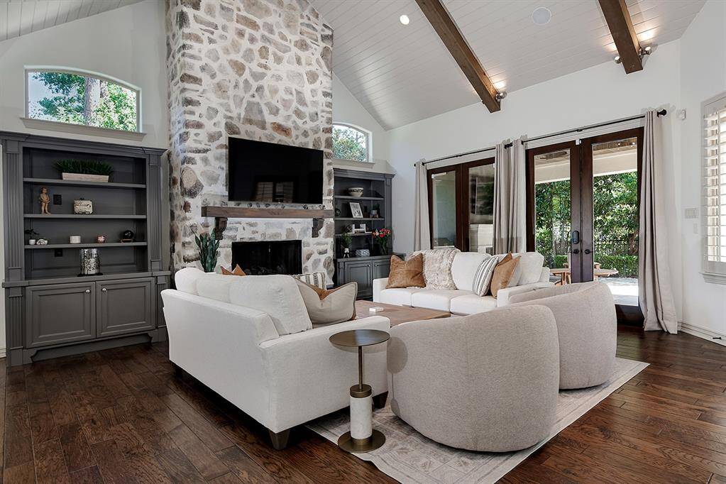 Stunning stone fireplace flanked by custom built-in cabinetry