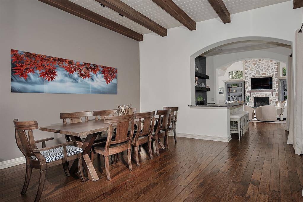 Versatile room features wood beams and brick accent wall