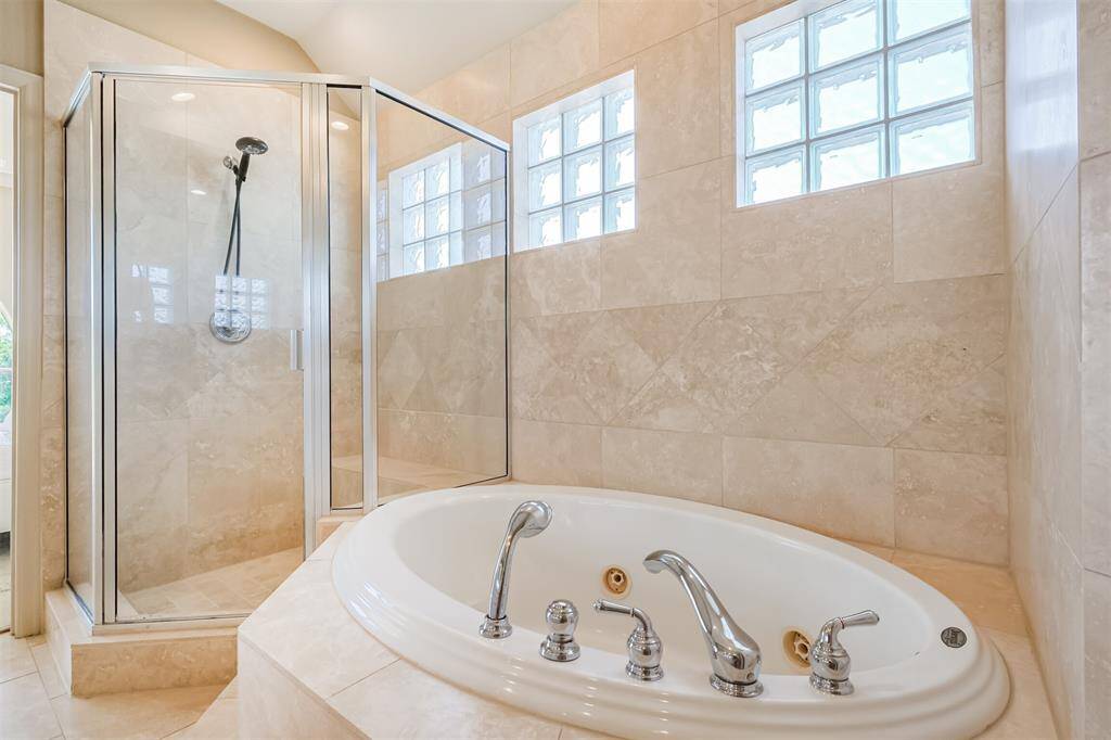 Soaking tub alongside a generous sized shower.