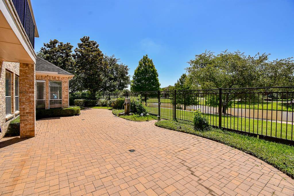 The expansive paved backyard has ample space for outdoor entertaining or quiet evenings by the water. Enclosed by a wrought iron fence, it blends openness with a sense of security while preserving the picturesque lake view.