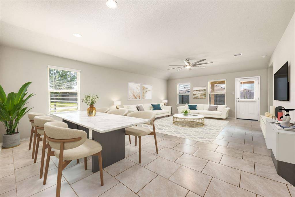 This living room is more like a GREAT room featuring neutral paint, high ceiling, ceiling fan with lighting, and an amazing wall of windows providing a lovely view of your backyard to keep an eye out on the kids or pets playing. *virtual staging*