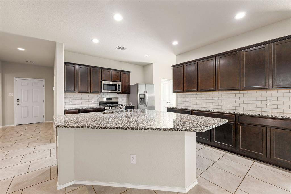This kitchen is by far any chef’s dream! This spacious kitchen features dark stained cabinets, granite countertops, SS appliances, modern tile backsplash, recessed lighting, extended counter space, granite kitchen island with double sink and space for breakfast bar all overlooking your huge family room.