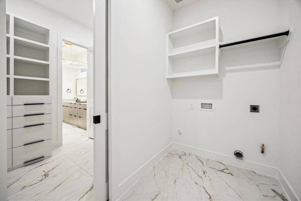 Laundry room with access from primary closet and mudroom.
