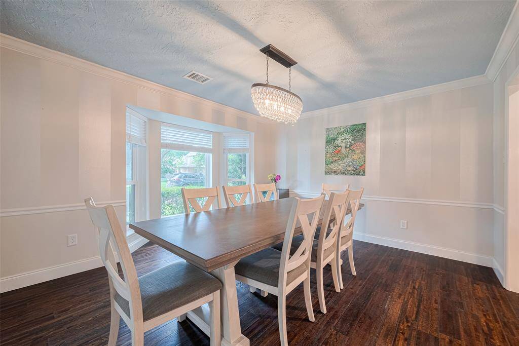 Spacious formal dining room featuring elegant crown molding installed in 2018 and new hardwood flooring added in 2020.