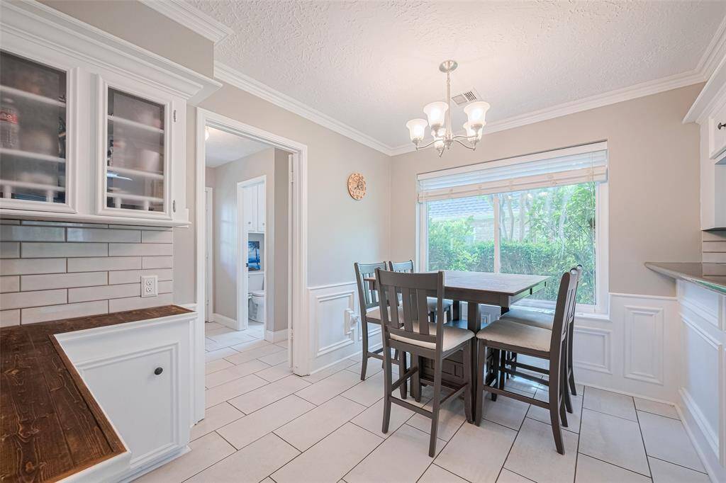 The bright breakfast area is filled with natural light, and the doorway conveniently connects to the powder room and utility room.