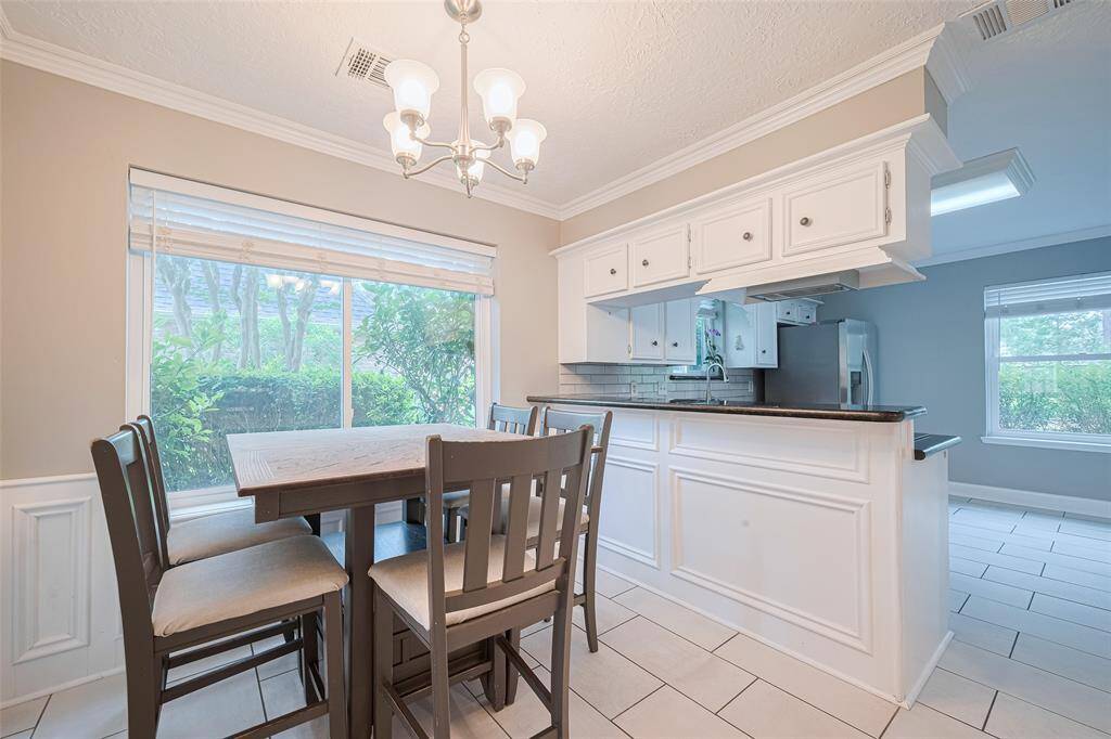 A different angle of the breakfast room, showcasing the porcelain tile flooring installed in 2022, which extends through the kitchen, hallway, utility room, and powder room.