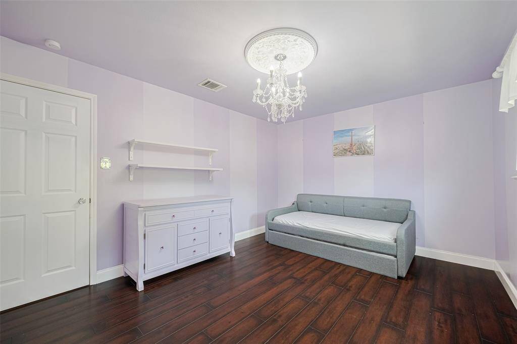 Secondary bedroom situated upstairs, featuring a spacious walk-in closet and laminate flooring installed in 2018.