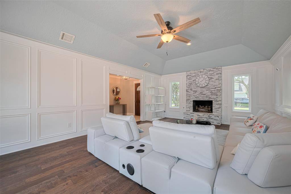 A different perspective of the formal living area, showcasing the inviting gas log fireplace and an abundance of natural light.