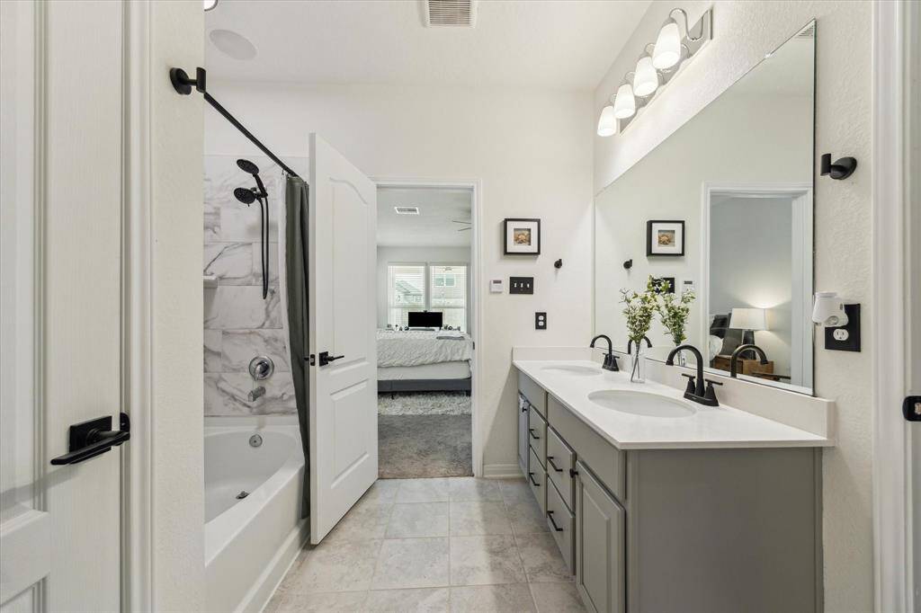 The primary bathroom features double sinks, a large soaking tub/shower combination, water closet, walk-in linen closet, and walk-in closet for clothes.