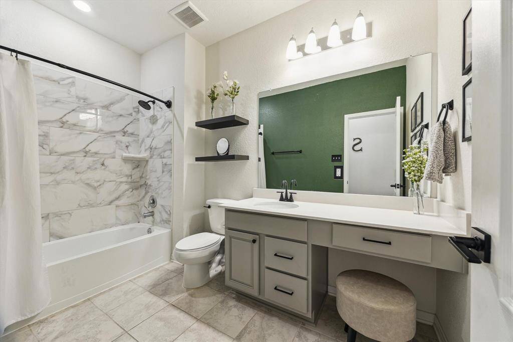 A full bathroom is conveniently located between both secondary bathrooms with vanity space.