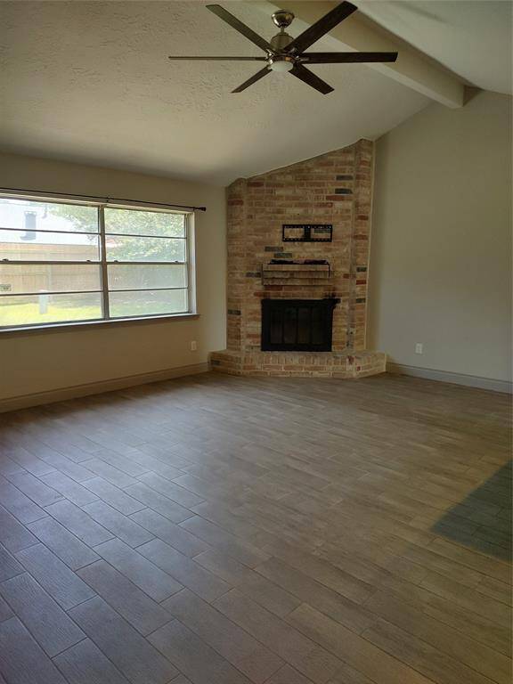 Family room with a brick wood burning fireplace.