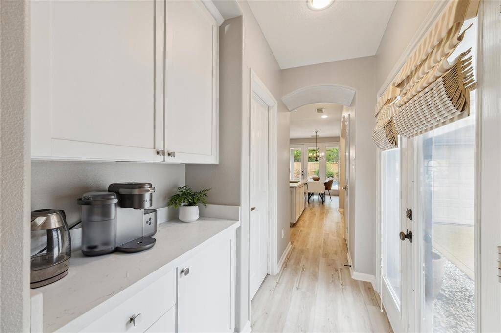 A view of the coffee station or buttler's pantry with its quartz countertops, and the exterior door to the porte-cochere