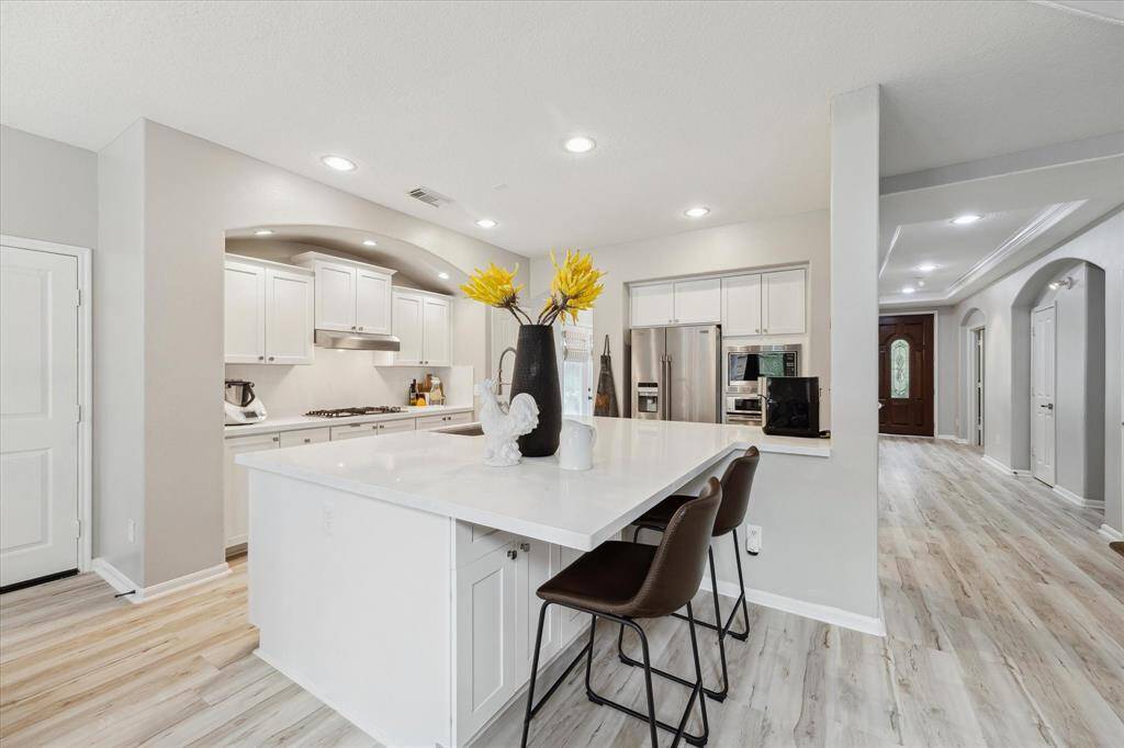 A view of the island and the upgraded kitchen and the stain steel appliances