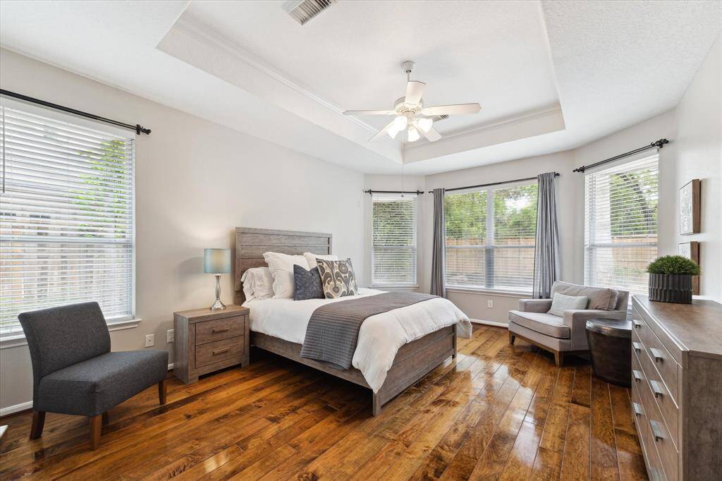 The master bedroom located in the first floor with its wood floors, great size, neutral colors and views of the pool