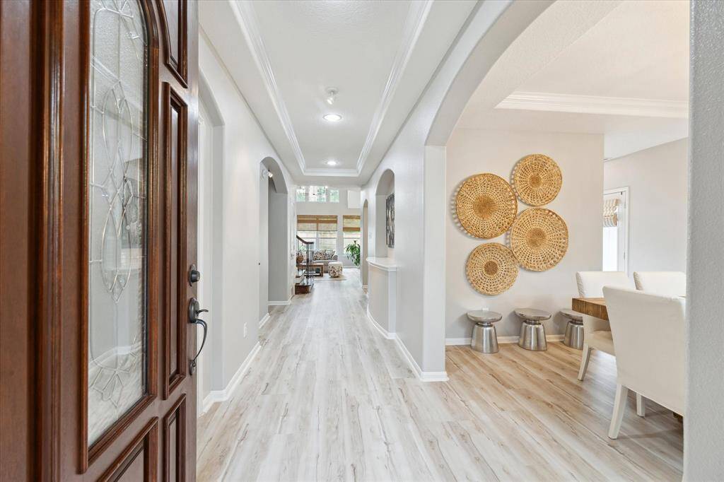 The foyer welcomes you with an amazing, upgraded flooring high ceiling , subtle colors and views of the pool