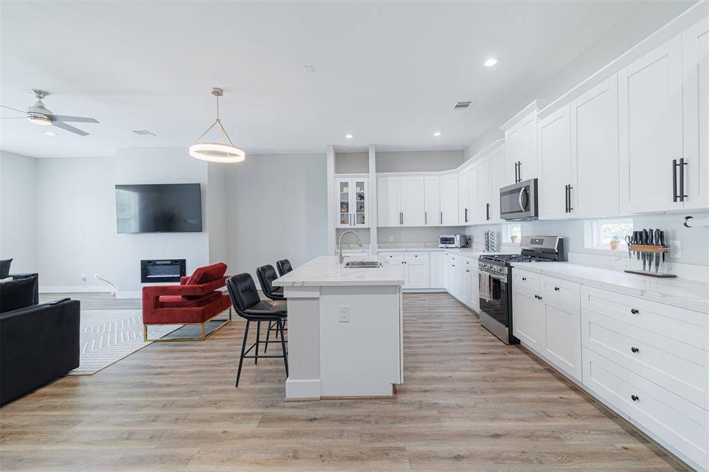 Gorgeous kitchen with modern touches has ample cabinetry and an island.