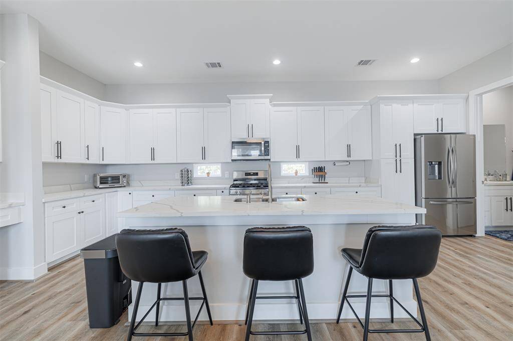 Kitchen also features a breakfast bar and recessed lighting.