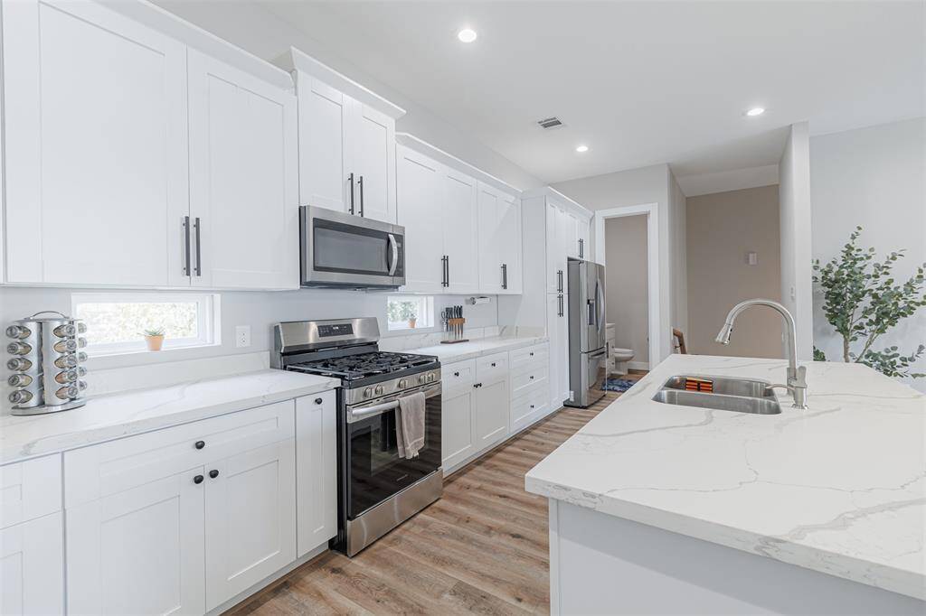 This kitchen also features transom windows on either side of the stove and stainless steel appliances.